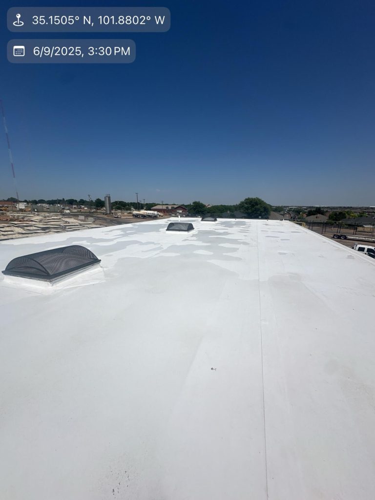 Bright white TPO commercial roof gleaming under clear blue skies on June 9, 2025, at 3:30 PM. The freshly heat-welded 60-mil TPO membrane shows perfect seams, two black dome skylight domes, and one screened turtle vent. Minor footprints and light dust are visible on the new surface. Location: 35.1505° N, 101.8802° W.