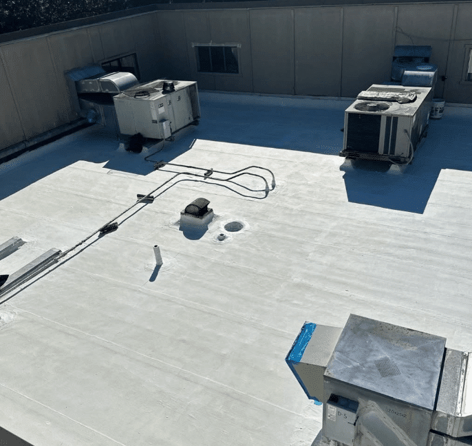 Flat commercial roof with HVAC units and white coating